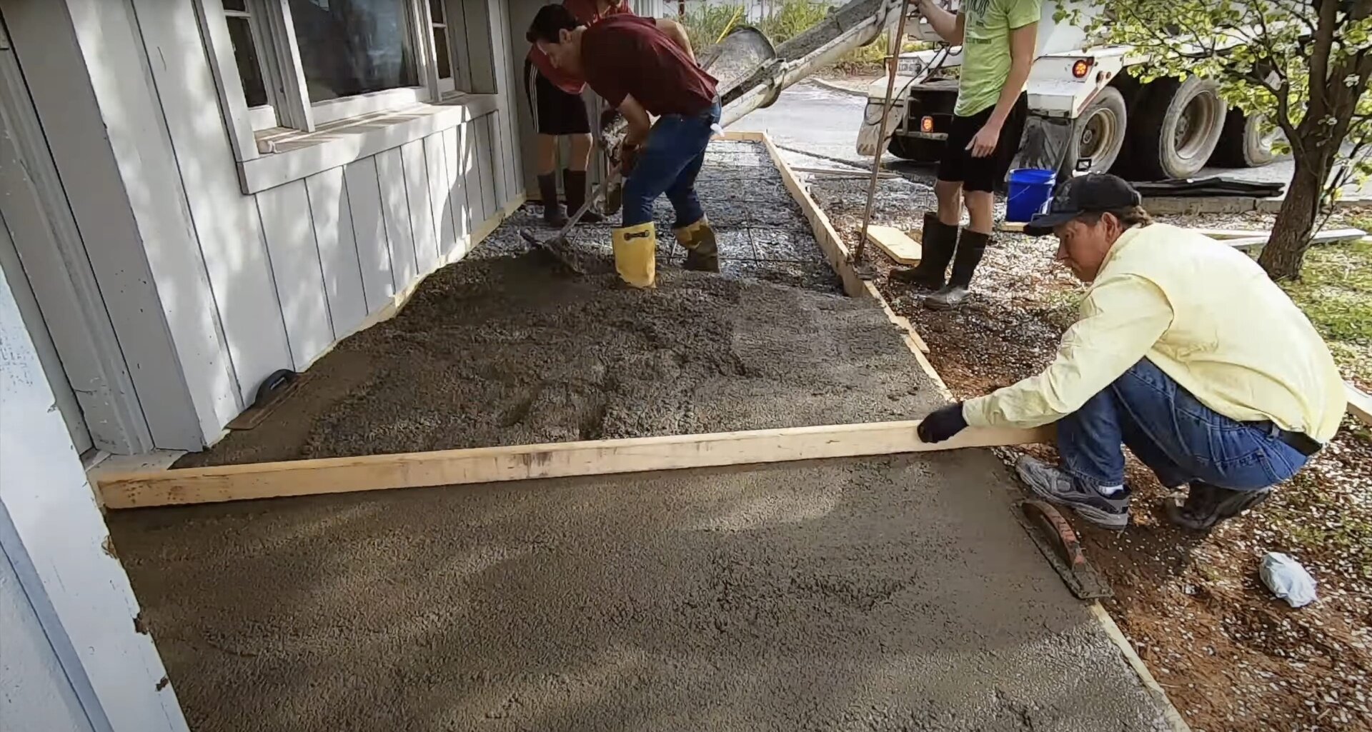 Professional concrete finishing work for residential patio installation Concrete contractors finishing residential patio with professional tools and techniques