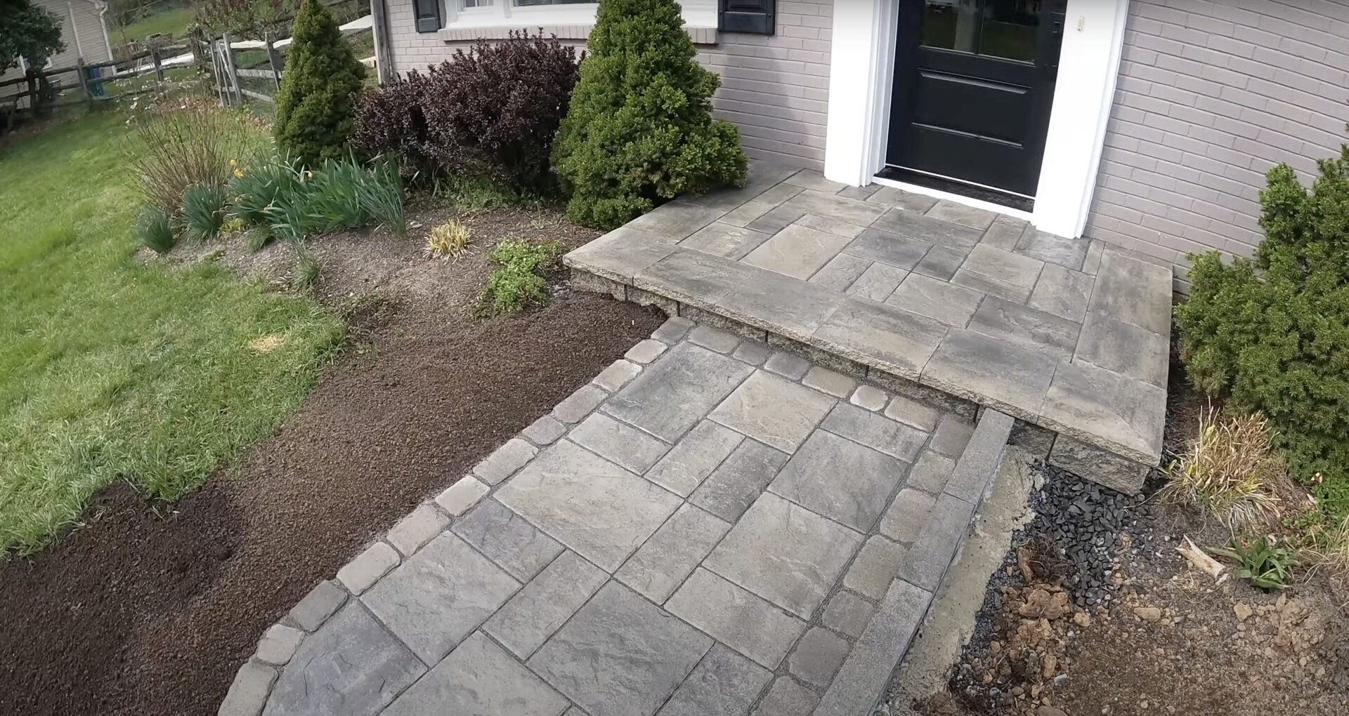 Completed concrete patio project with decorative elements Beautiful concrete patio with decorative pavers and professional landscaping